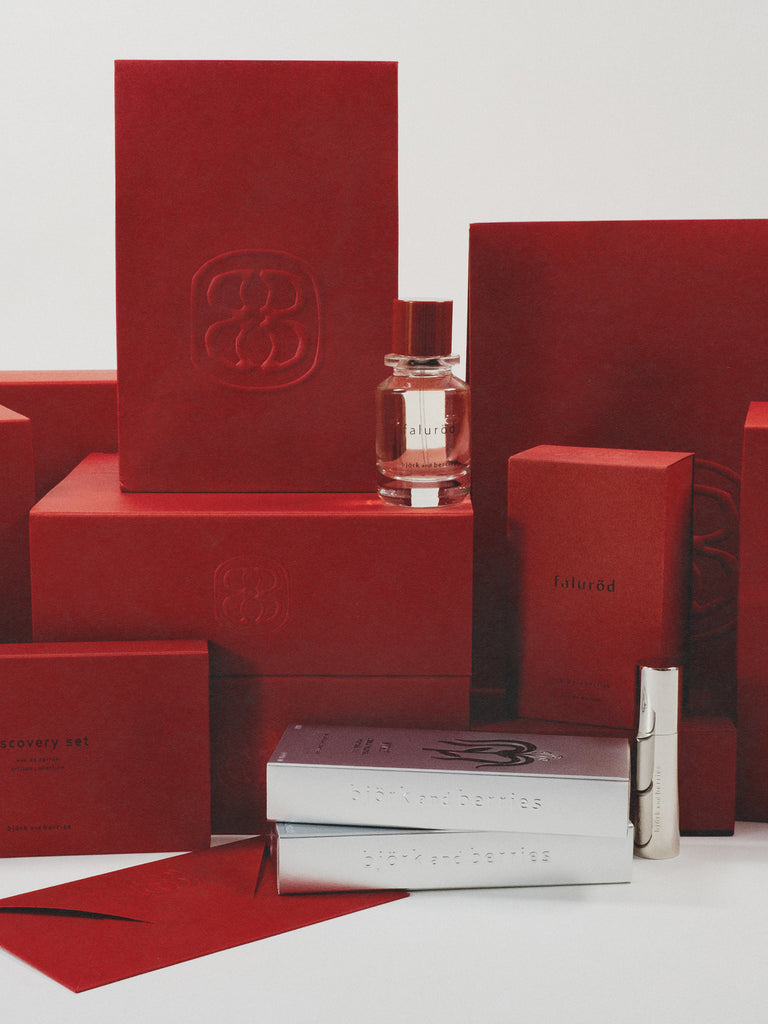 Red boxes with a perfume bottle and silver packages on a white background