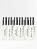 Six travel sized bottles of björk and berries eau de perfume standing next to one another. White forrest, Fjällsjö, botanist, never spring, mareld and september,  standing against a white background. 